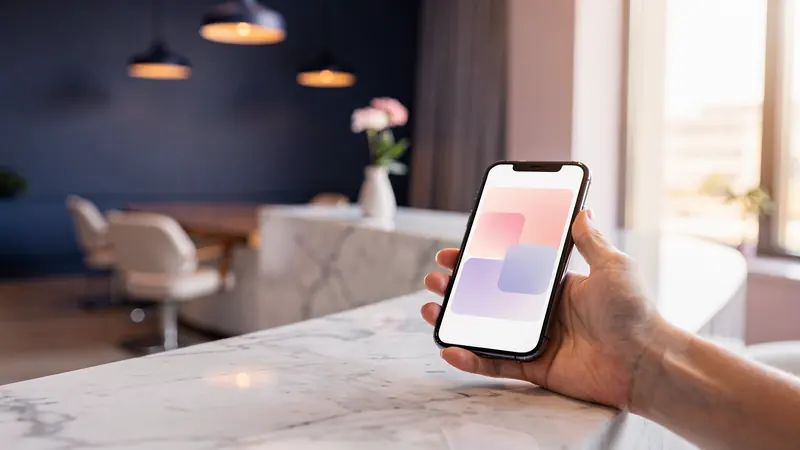 A hand holding a phone with a booking calendar at the marble reception desk of a calm salon.